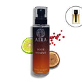 Dior Homme body splash bottle with lime, wood piece, and red berries on a white background