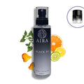 Aira Black XS body splash bottle with citrus fruits and leaves on a white background