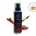 Aira Khamrah body splash bottle with cinnamon, vanilla, and dates on a white background